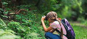 Mädchen beobachtet und fotografiert die Natur
