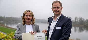 Steffi Lemke und WWF-Vorstand Jan-Peter Schemmel halten die Förderurkunde ins Bild.